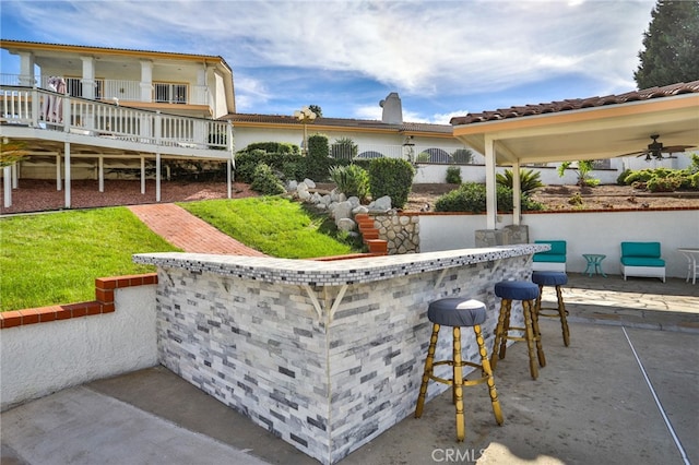 view of patio / terrace with ceiling fan and a bar