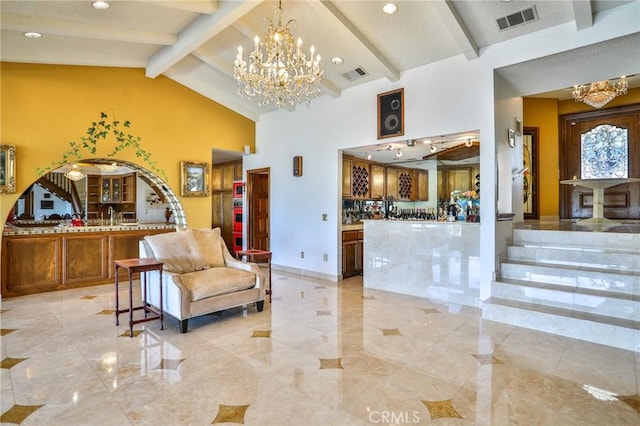 living room featuring an inviting chandelier, beamed ceiling, and high vaulted ceiling