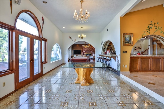 entrance foyer featuring a textured ceiling, french doors, and an inviting chandelier