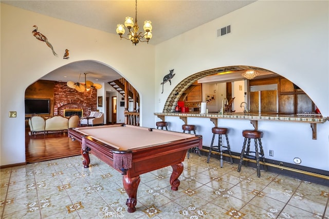 game room featuring an inviting chandelier, light tile patterned flooring, a fireplace, and billiards