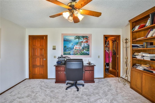 home office featuring ceiling fan, light colored carpet, and a textured ceiling