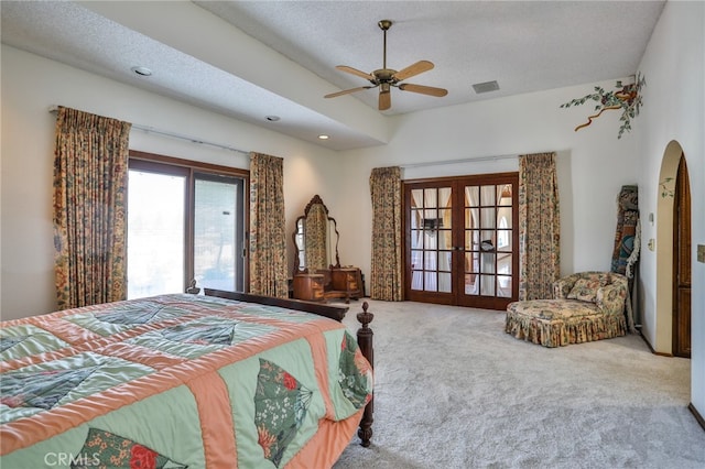 carpeted bedroom with ceiling fan, french doors, and a textured ceiling