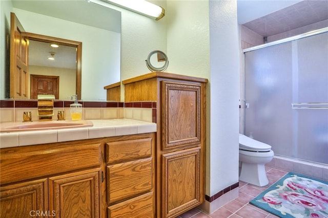 bathroom featuring toilet, tile patterned floors, walk in shower, and vanity