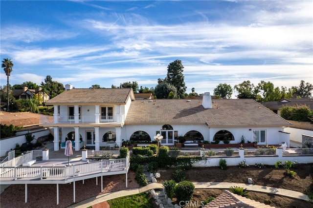 back of property featuring a balcony and a patio