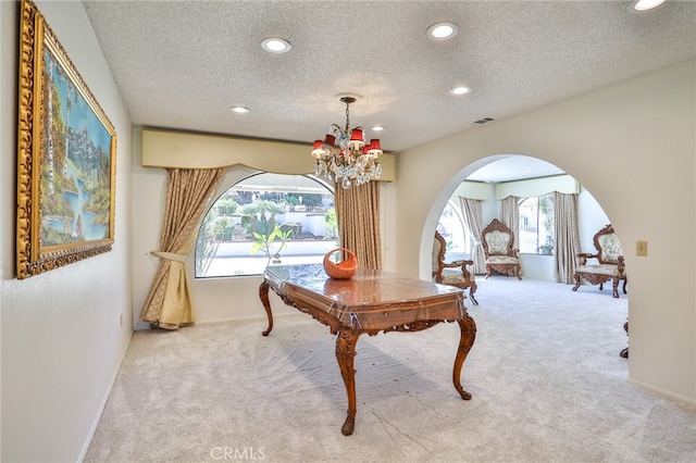 interior space with light carpet, an inviting chandelier, and a textured ceiling