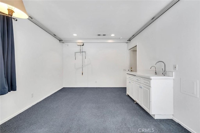 basement with dark colored carpet and sink