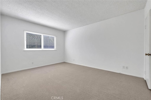 carpeted empty room with a textured ceiling