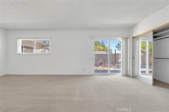 carpeted empty room with a textured ceiling