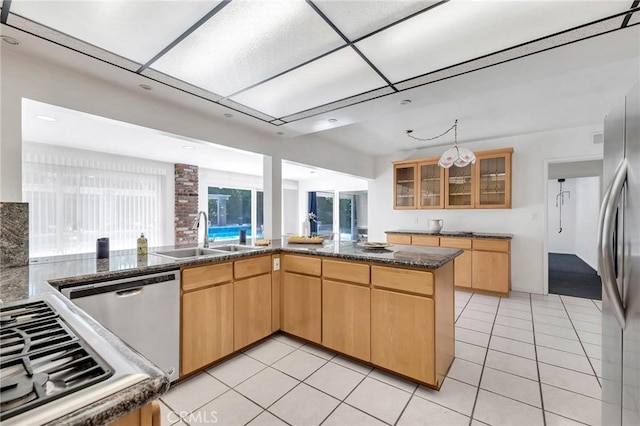 kitchen with sink, kitchen peninsula, light brown cabinetry, light tile patterned floors, and appliances with stainless steel finishes