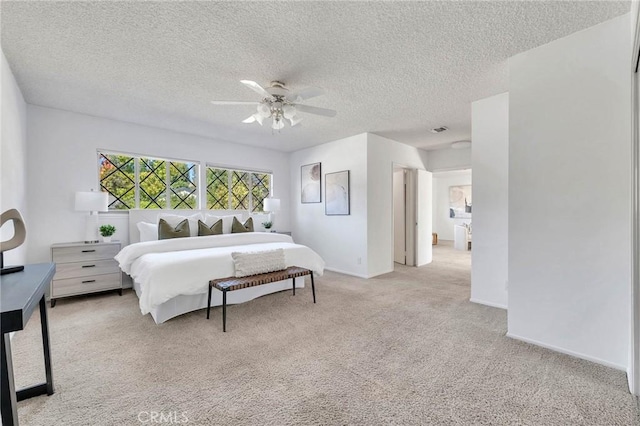 bedroom with ceiling fan, light colored carpet, and a textured ceiling