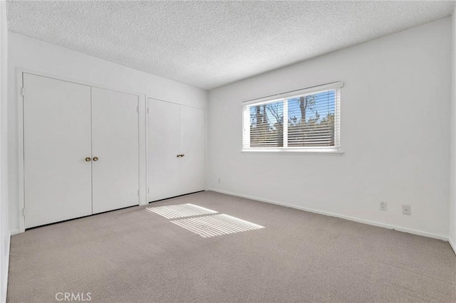 unfurnished bedroom featuring light colored carpet and a textured ceiling