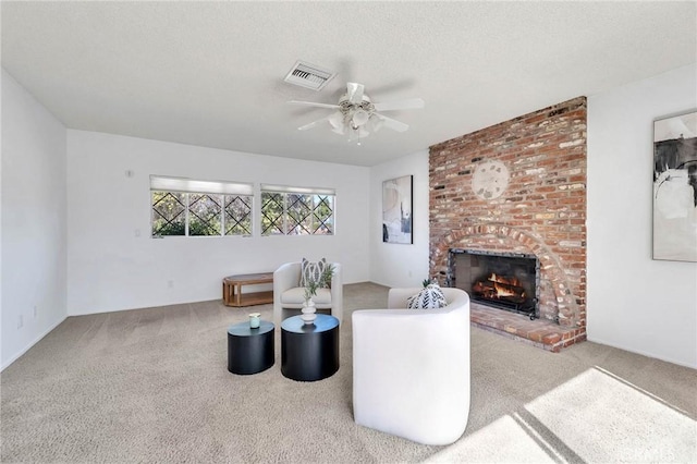 living room with carpet, a textured ceiling, ceiling fan, and a fireplace