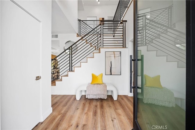 stairs featuring hardwood / wood-style floors and a towering ceiling