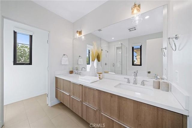 bathroom with tile patterned flooring, vanity, a shower with door, and a healthy amount of sunlight