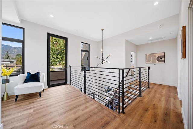 corridor featuring a notable chandelier, a mountain view, and light hardwood / wood-style flooring