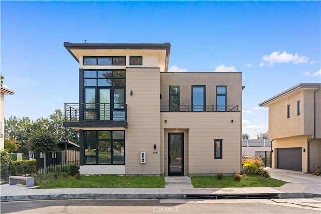 contemporary house featuring a garage and a balcony