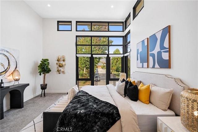 bedroom featuring a towering ceiling and light colored carpet