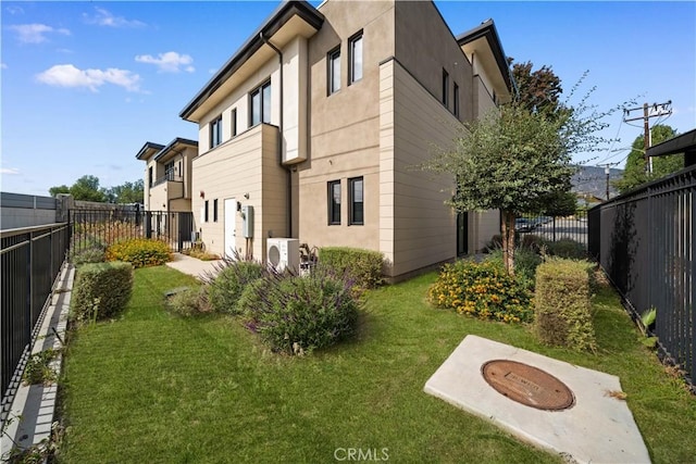 view of side of home featuring a lawn and ac unit