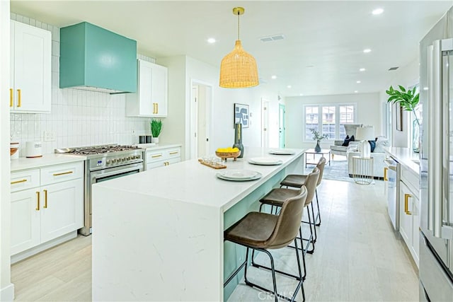2942 S W View St, Los Angeles, CA 90016 - kitchen with appliances with stainless steel finishes, decorative backsplash, white cabinets, recessed lighting, and a kitchen island