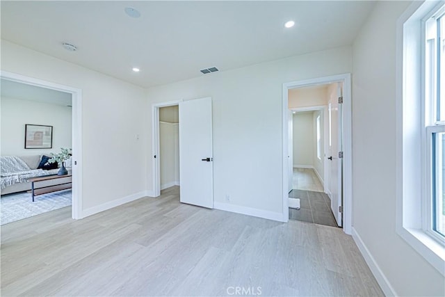 2942 S W View St, Los Angeles, CA 90016 - unfurnished bedroom with light wood finished floors, baseboards, recessed lighting, and a walk in closet