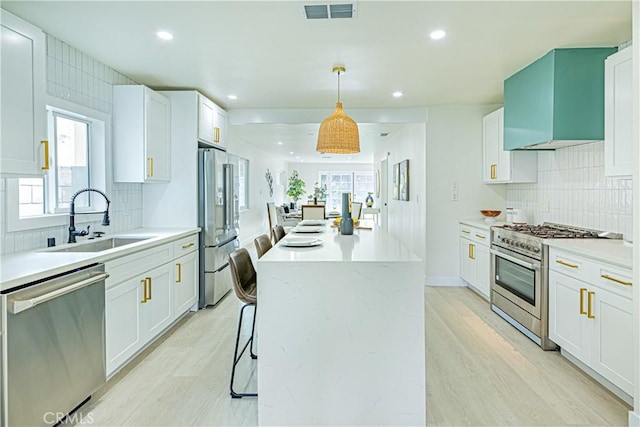 2942 S W View St, Los Angeles, CA 90016 - kitchen featuring appliances with stainless steel finishes, a sink, a kitchen island, recessed lighting, and tasteful backsplash