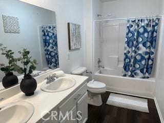 full bathroom featuring shower / bath combo with shower curtain, vanity, hardwood / wood-style floors, and toilet