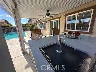 view of patio featuring ceiling fan and a fenced in pool