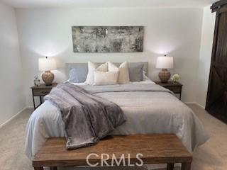 carpeted bedroom with a barn door