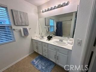 bathroom with a shower with curtain, plenty of natural light, tile patterned floors, and vanity