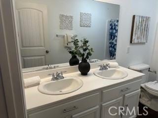 bathroom with a shower with shower curtain, vanity, and toilet