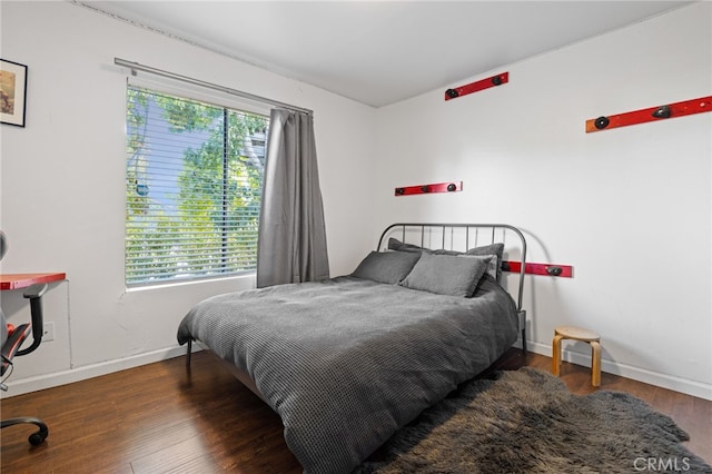 bedroom with dark hardwood / wood-style flooring