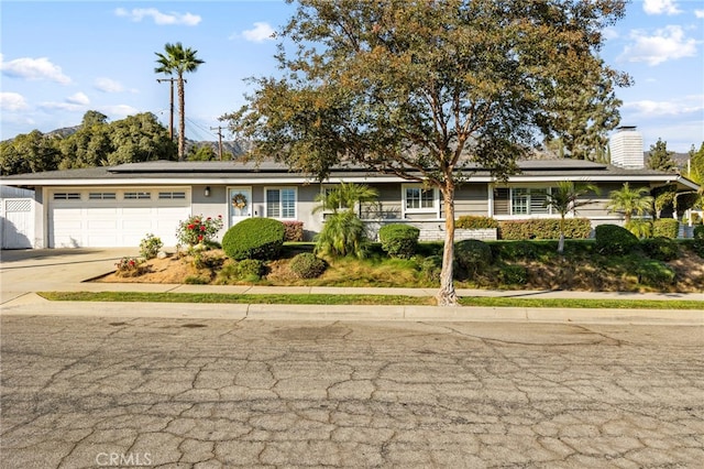 single story home featuring solar panels and a garage