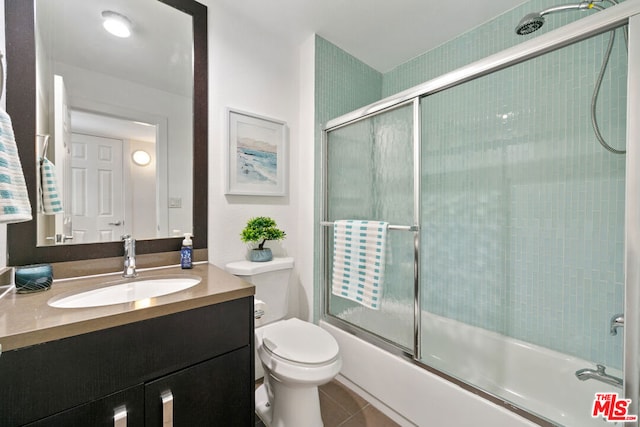 full bathroom with tile patterned flooring, vanity, toilet, and enclosed tub / shower combo