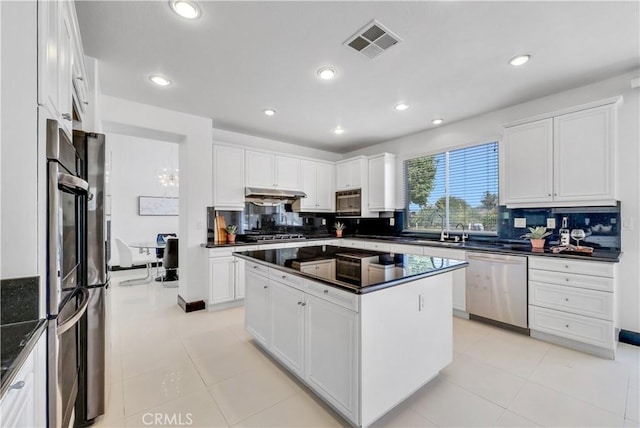 kitchen featuring tasteful backsplash, appliances with stainless steel finishes, a center island, and white cabinets