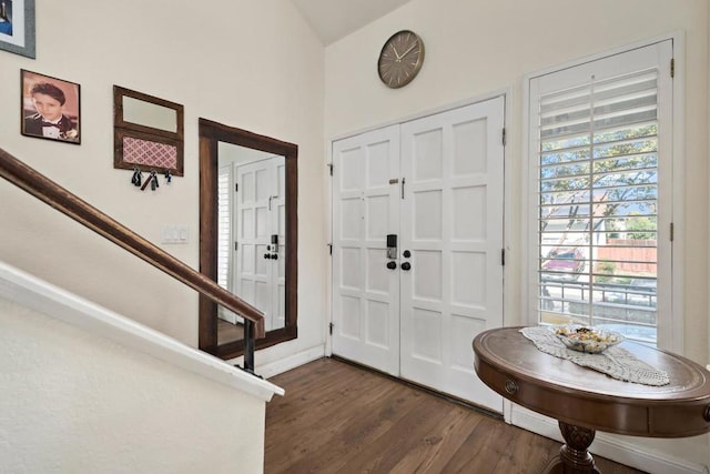 foyer featuring dark hardwood / wood-style floors and lofted ceiling