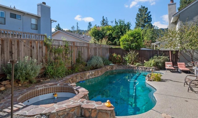 view of swimming pool featuring an in ground hot tub and a patio