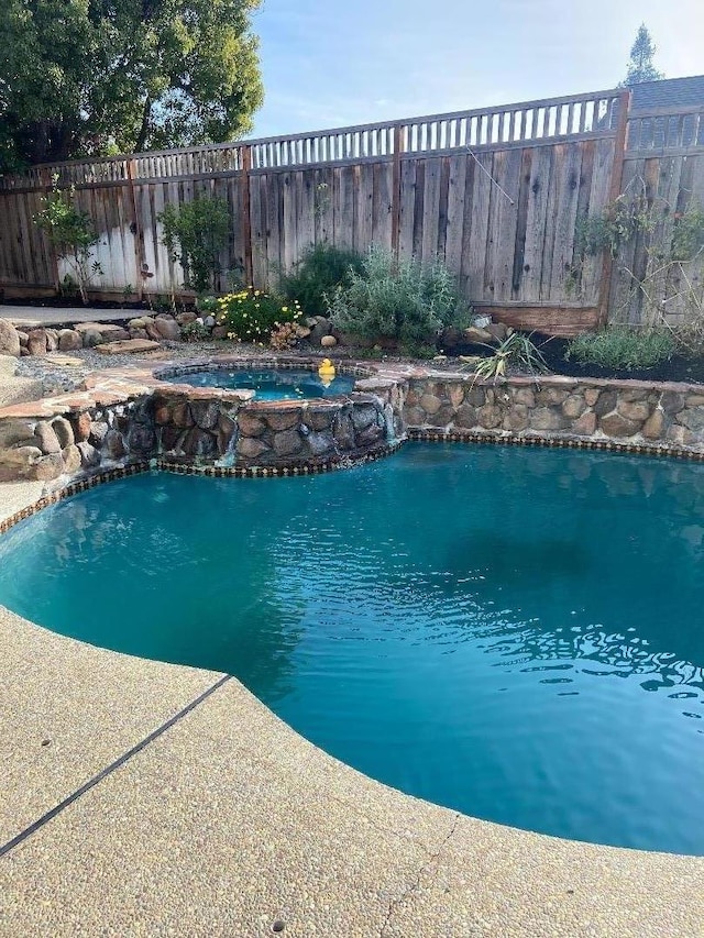 view of pool with an in ground hot tub