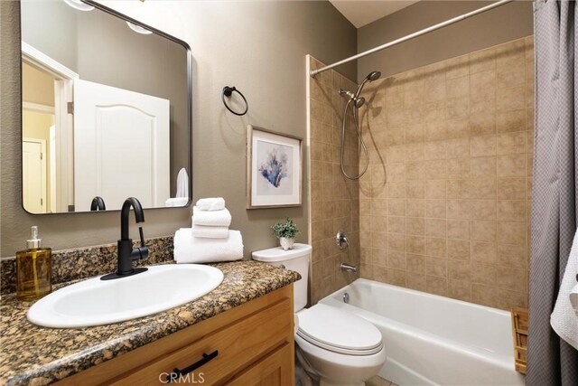 full bathroom featuring toilet, vanity, and shower / bathtub combination with curtain