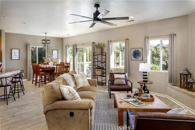 living room featuring ceiling fan and light hardwood / wood-style floors