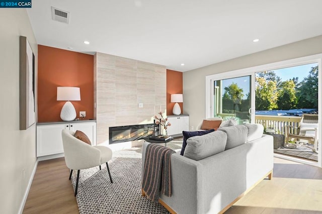 living room featuring light hardwood / wood-style flooring and a tile fireplace