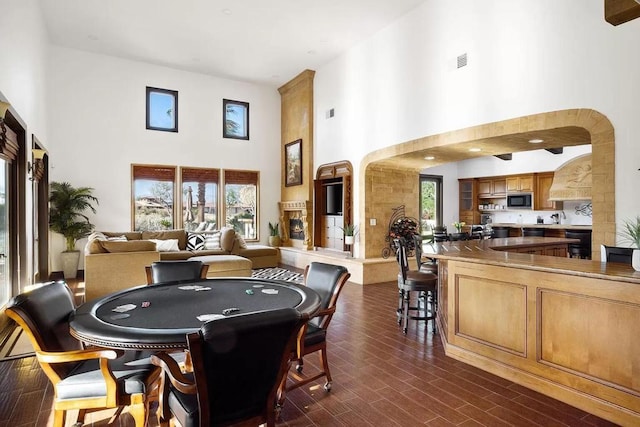 recreation room featuring dark hardwood / wood-style flooring and a towering ceiling