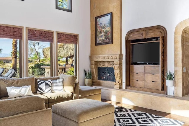 living room with a towering ceiling and hardwood / wood-style flooring