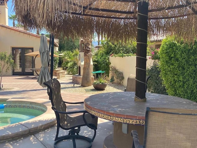 view of patio featuring an in ground hot tub and french doors