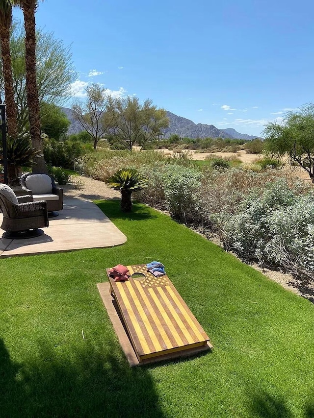 view of property's community with a mountain view and a yard