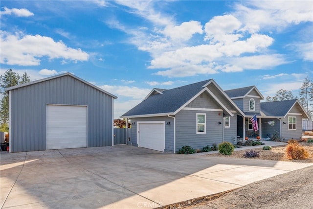 view of front of home featuring a garage and an outbuilding