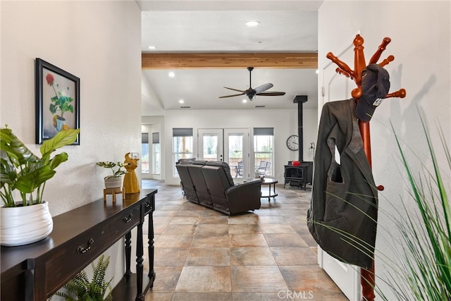 living room with vaulted ceiling with beams, a wood stove, french doors, and ceiling fan