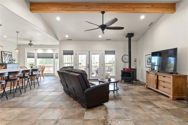 living room with ceiling fan, high vaulted ceiling, a wood stove, and beamed ceiling