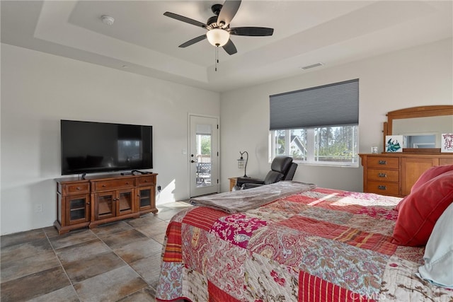 bedroom featuring a raised ceiling, access to outside, and ceiling fan