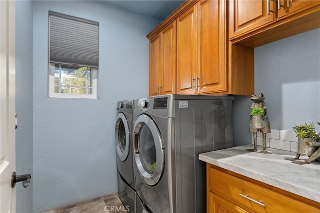 washroom with washer and dryer and cabinets