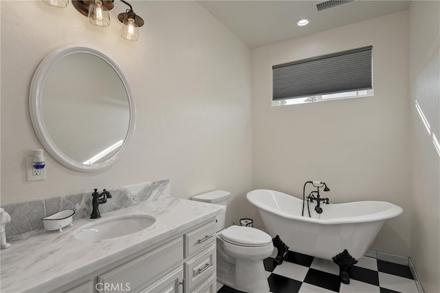 bathroom featuring vanity, toilet, and a washtub